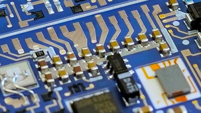 A blue printed circuit board from CeramTec with passive components.