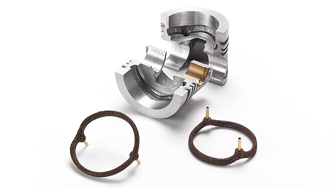 A silver piece of metal and brown salt cores for foundry technology