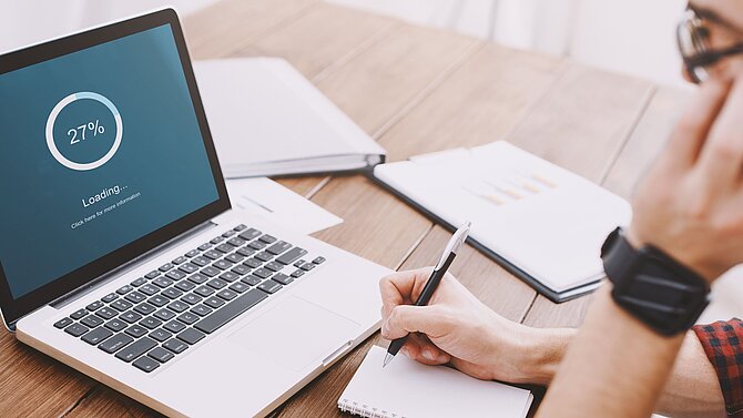 Man looks into screen during download